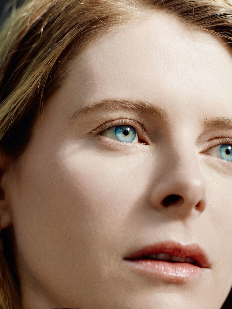 Close up portrait of a woman with bright blue eyes and blonde hair photographed by Caroline Tompkins.