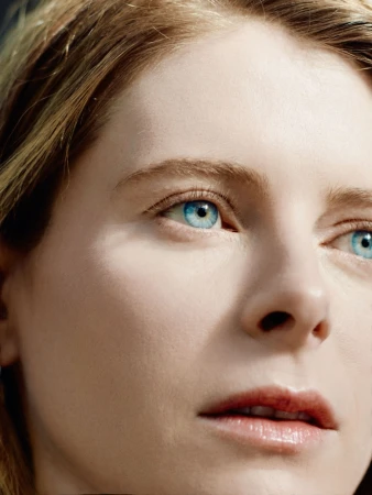 Close up portrait of a woman with bright blue eyes and blonde hair photographed by Caroline Tompkins.