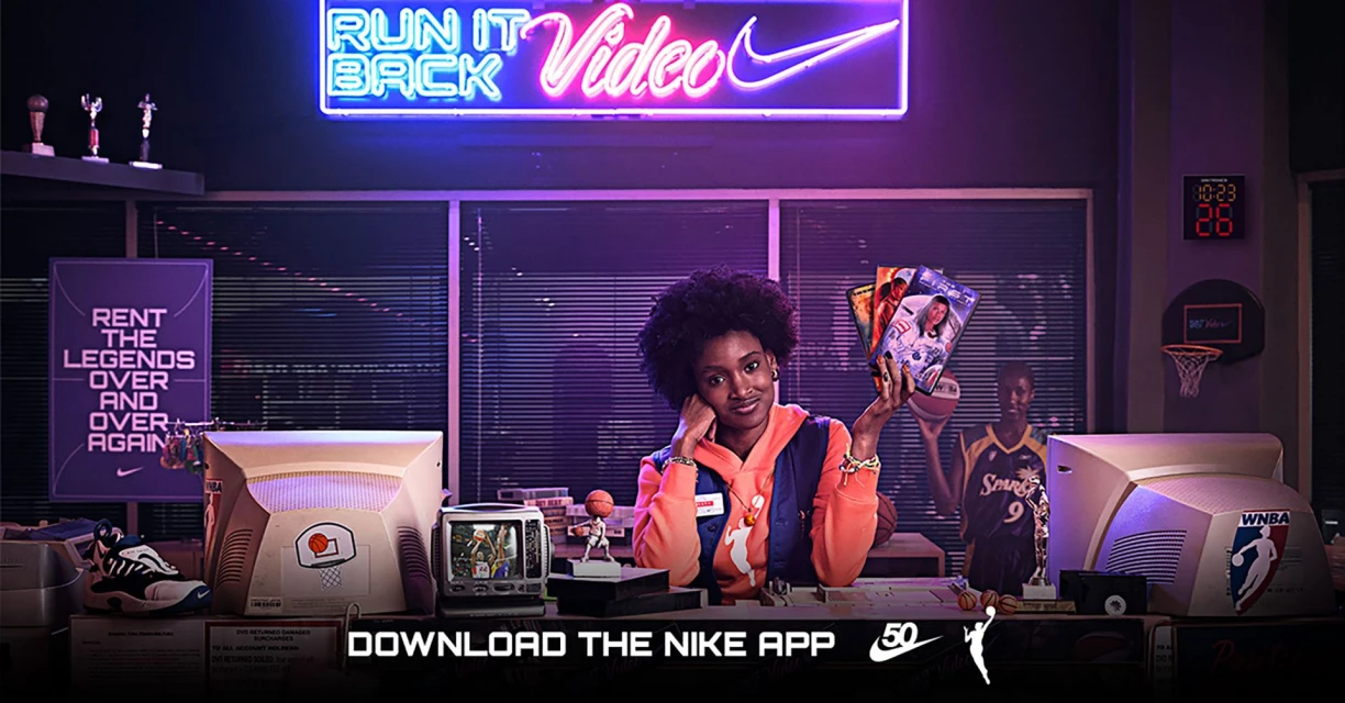 A young woman surrounded by basketball memorabilia promoting Nike's 'Run it Back Video' campaign in a vintage office setting.