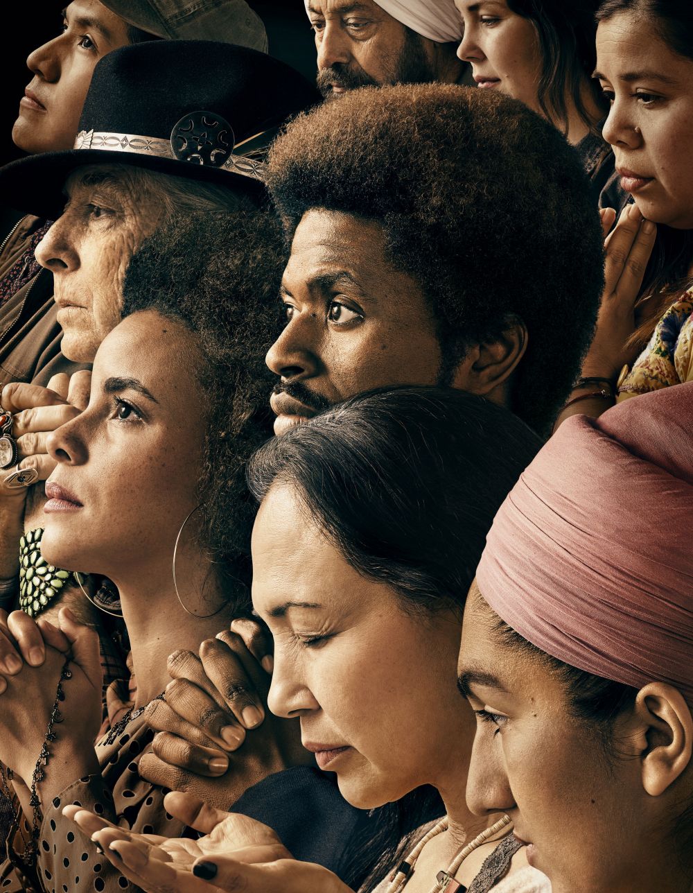 Diverse group of people looking upward. The group is made up of men and women of various ages, complexions, and cultural backgrounds.