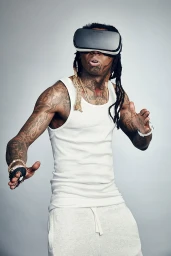 Lil Wayne wearing VR headset and white tank top in portrait photograph by Emily Shur against a grey studio backdrop.