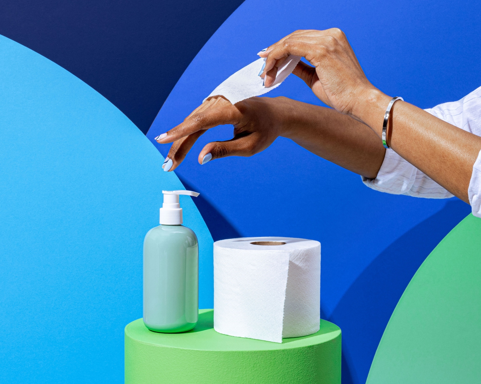 Sanitizing hands with dispenser soap and paper towel on a green podium against a blue wavy background in a modern, clean aesthetic.