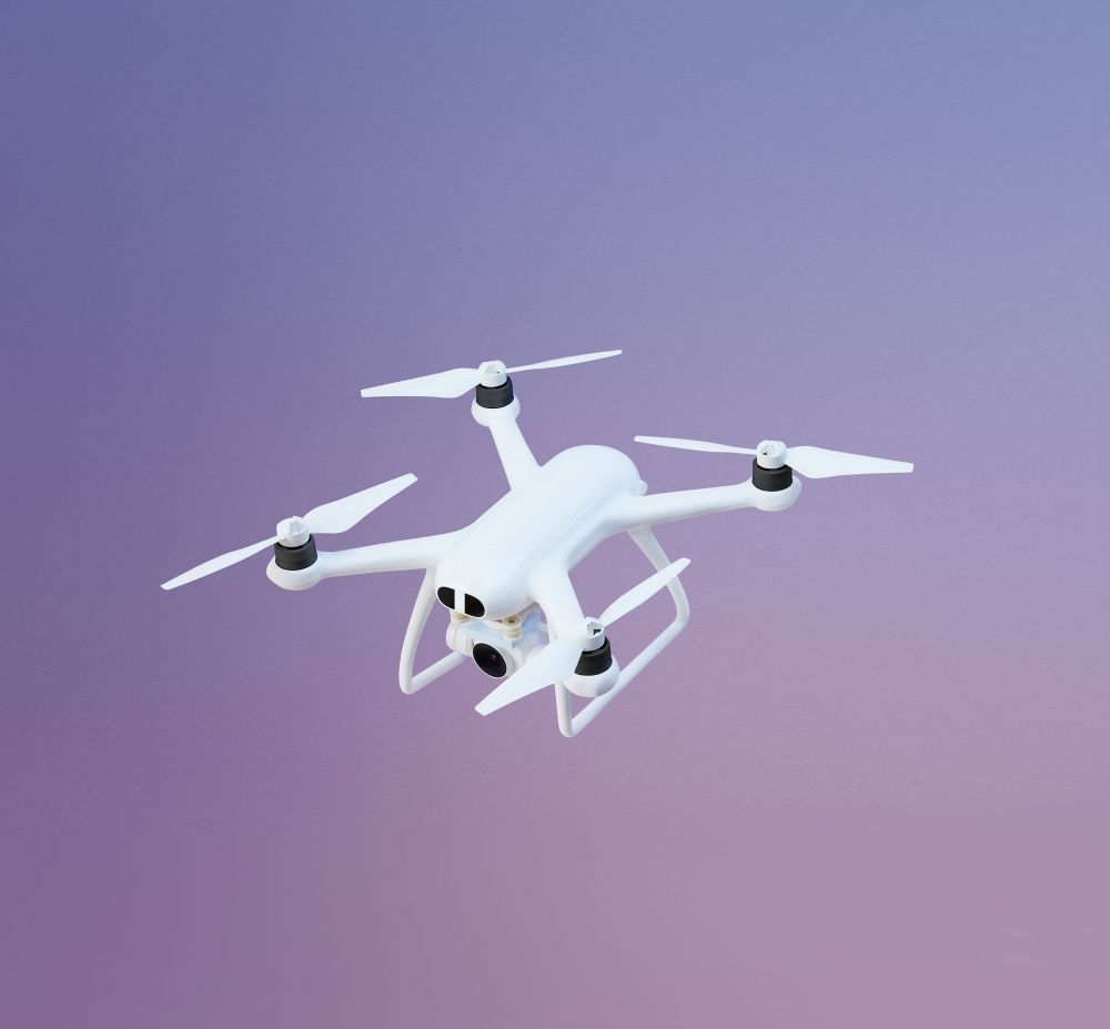 Drone against a purple-pink gradient backdrop. The drone is white with four propellers and a camera visible at the front.