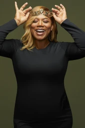 Queen Latifah wearing a gold crown and black long-sleeve dress against a dark green backdrop