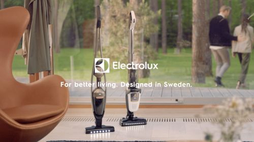 Image showcases Electrolux vacuum cleaners indoors with natural light, alongside modern chair, couple walking outside, and view of trees.
