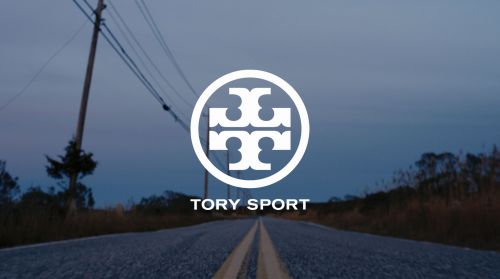 Tory Sport logo on a desolate road at dusk, creating a sense of determination and forward motion. The open road symbolizes journey.