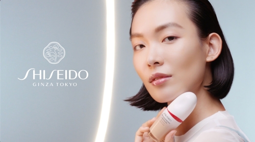 Elegant Asian woman showcases Shiseido Ginza Tokyo foundation. Soft lighting, neutral tones, beauty advertisement.