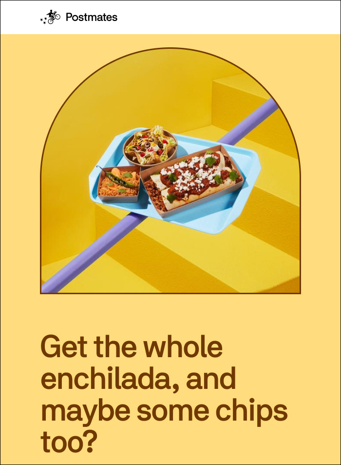 Overhead shot of an enchilada meal and chips on a blue tray, styled on yellow steps with a pale purple bar. Food delivery concept.