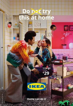 A colorful IKEA ad in a tiled bathroom features a man applying makeup to a woman near a NISSAFORS trolley, alongside a pink orchid.