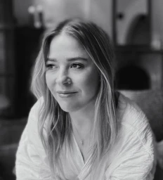 Black and white portrait of a woman with long hair wearing a light textured top indoors in Los Angeles.