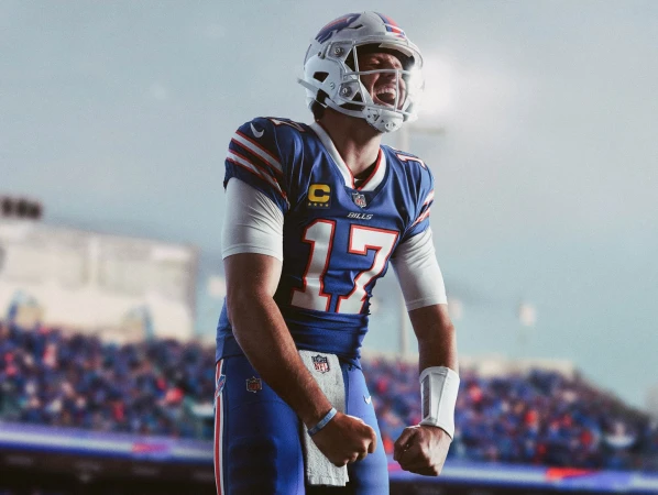 American football quarterback in a Bills uniform celebrates a play on the field with fans in the background. Excitement in sports.
