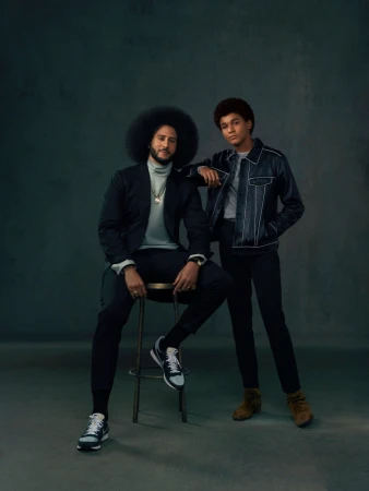 Portrait of two men in dark attire against a grey textured studio backdrop, photographed by Marcus Smith in Los Angeles.