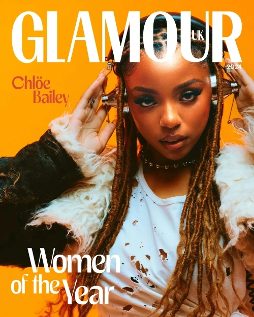 Glamour UK magazine cover features Chloë Bailey wearing headphones, a white ripped t-shirt, and a fur-lined jacket against an orange background.