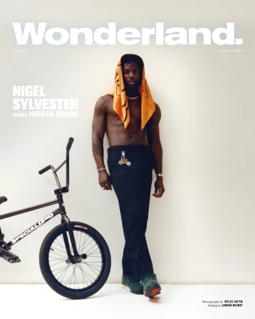 Magazine cover featuring Nigel Sylvester in black pants with a BMX bike, set against a white wall backdrop.