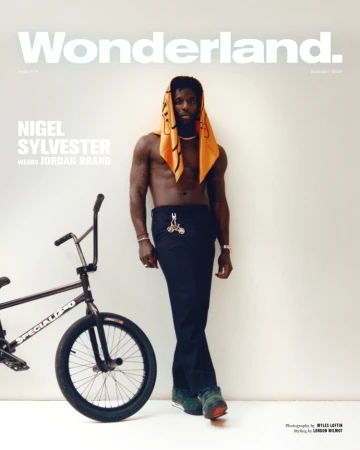 Magazine cover featuring Nigel Sylvester in black pants with a BMX bike, set against a white wall backdrop.