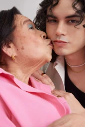 Elderly woman kissing a young man on the cheek in a close-up portrait by photographer Myles Loftin.