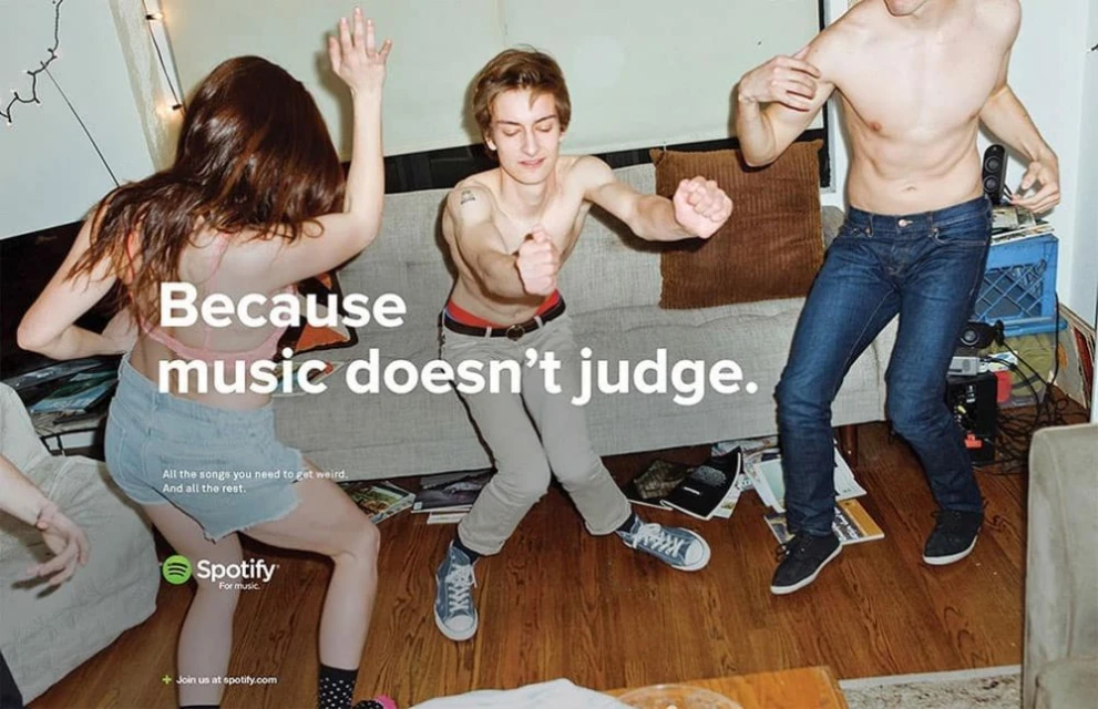 Group of young adults dancing indoors to Spotify, celebrating music's freedom. Casual, vibrant scene with a focus on joyful movement and energy.