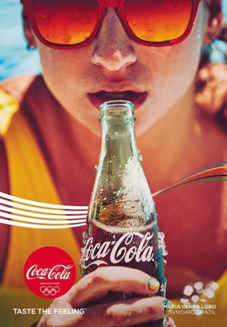 Close-up of a woman drinking Coca-Cola from a bottle, wearing sunglasses. The image is stylized as an advertisement.