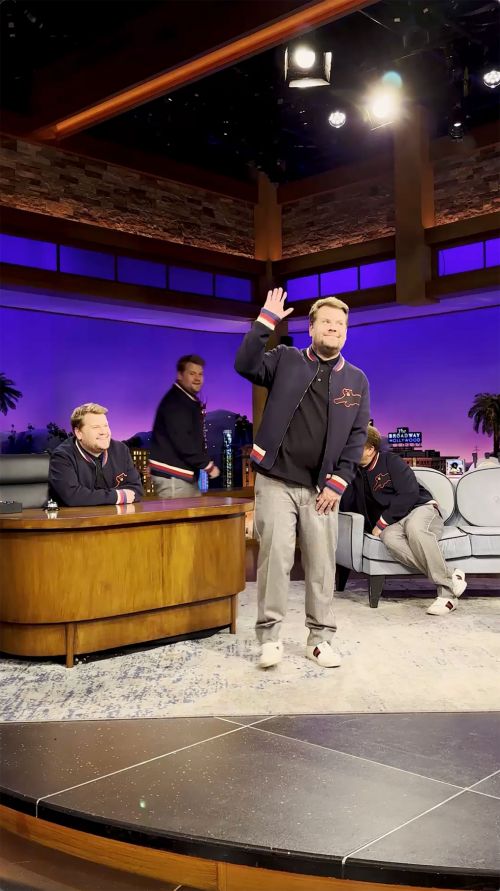 Multiple James Cordens on a TV set with a desk, couch and city backdrop, one standing and waving his hand.