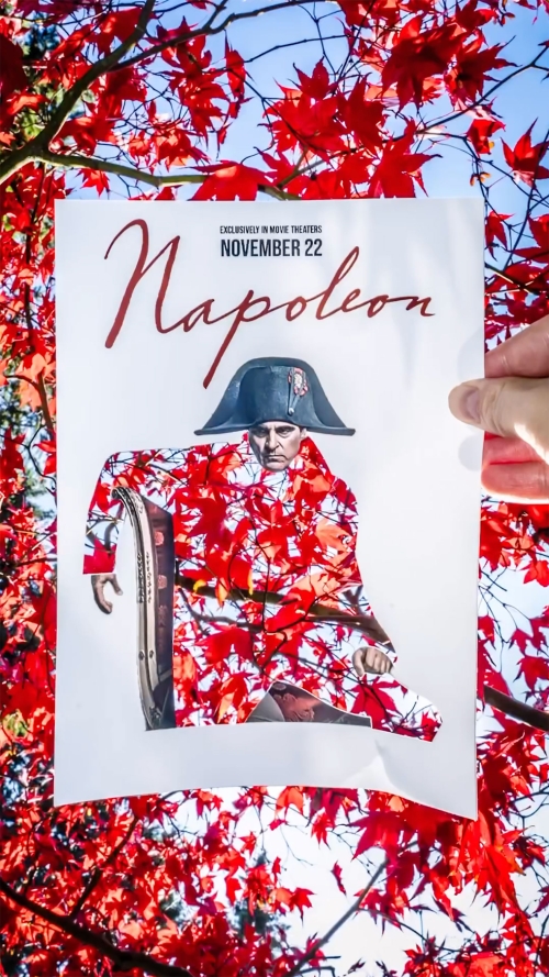 Promotional poster featuring Napoleon in autumn setting with red maple leaves, held in someone's hand for a theater event.