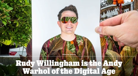 Hand holding a cut-out paper portrait featuring a man wearing reflective sunglasses and a botanical print t-shirt aligned with real foliage.