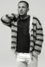 Portrait of Charlie Puth wearing a fuzzy striped cardigan against a white seamless background photographed by Todd Cole