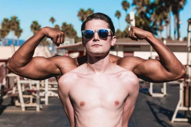 A man wearing sunglasses flexing biceps outdoors with an optical illusion blending arms behind him
