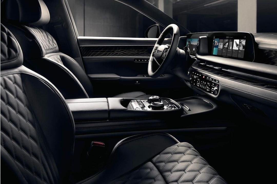 Luxurious car interior featuring quilted leather seats, a sleek dashboard with integrated screens, and sophisticated design elements.