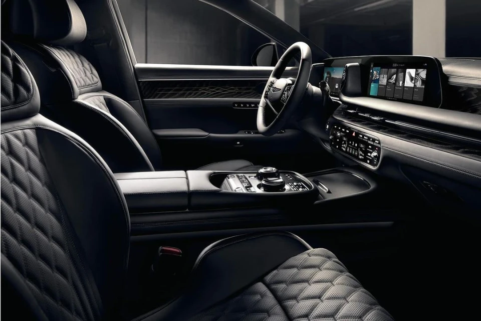 Luxurious car interior featuring quilted leather seats, a sleek dashboard with integrated screens, and sophisticated design elements.