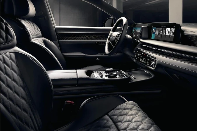 Luxurious car interior featuring quilted leather seats, a sleek dashboard with integrated screens, and sophisticated design elements.