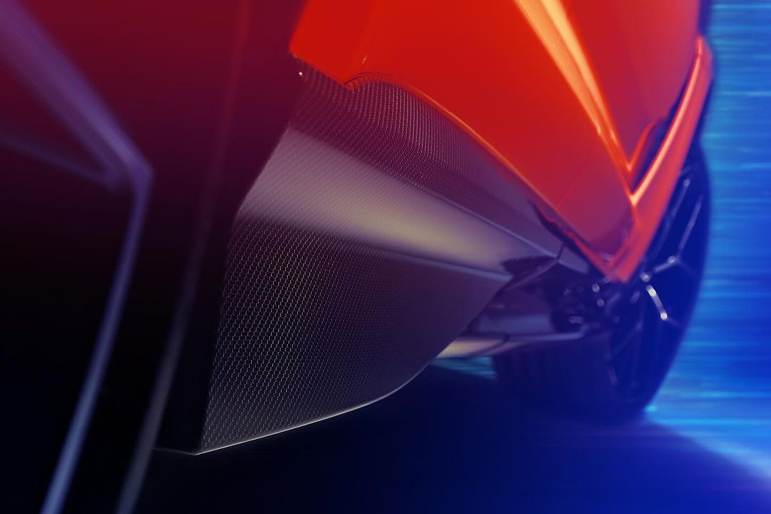 Close-up shot of a vibrant orange automobile with sleek carbon fiber detailing and a modern wheel design, set against a dynamic blue background.