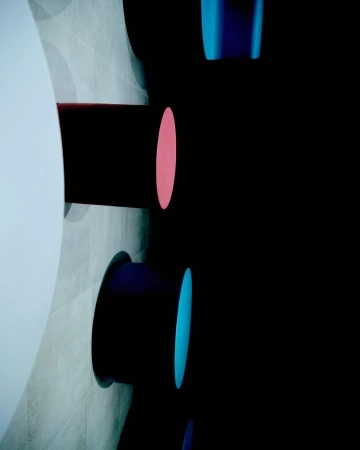 Abstract architectural detail featuring cylindrical shapes against a tiled wall and dark background, highlighted with vibrant pink and blue accents.