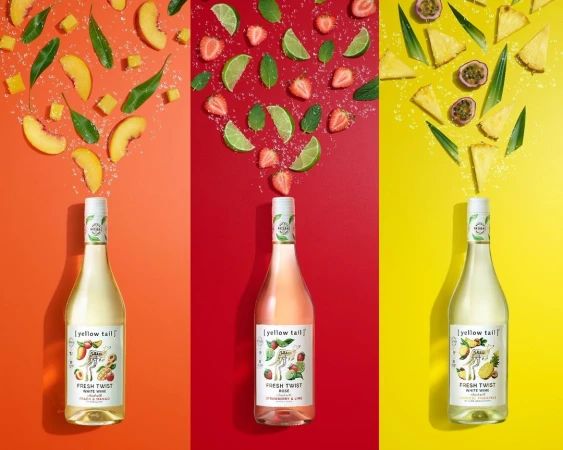 Three bottles of Yellow Tail Fresh Twist wine, each paired with matching fruit ingredients on a color-blocked orange, red, and yellow background.