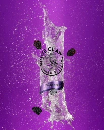 Water splash and floating blackberries against a vibrant purple background, captured by Vijey Mohan.