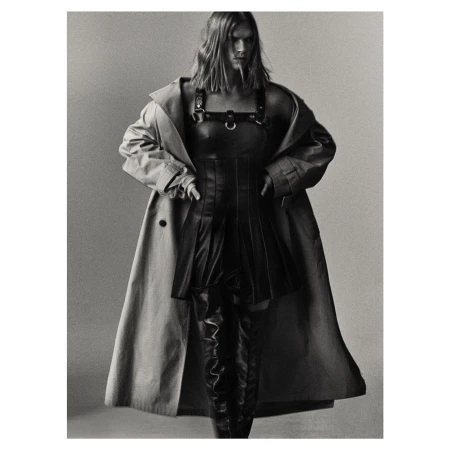 Model wearing a pleated leather dress, harness, and trench coat by Alistair Taylor-Young