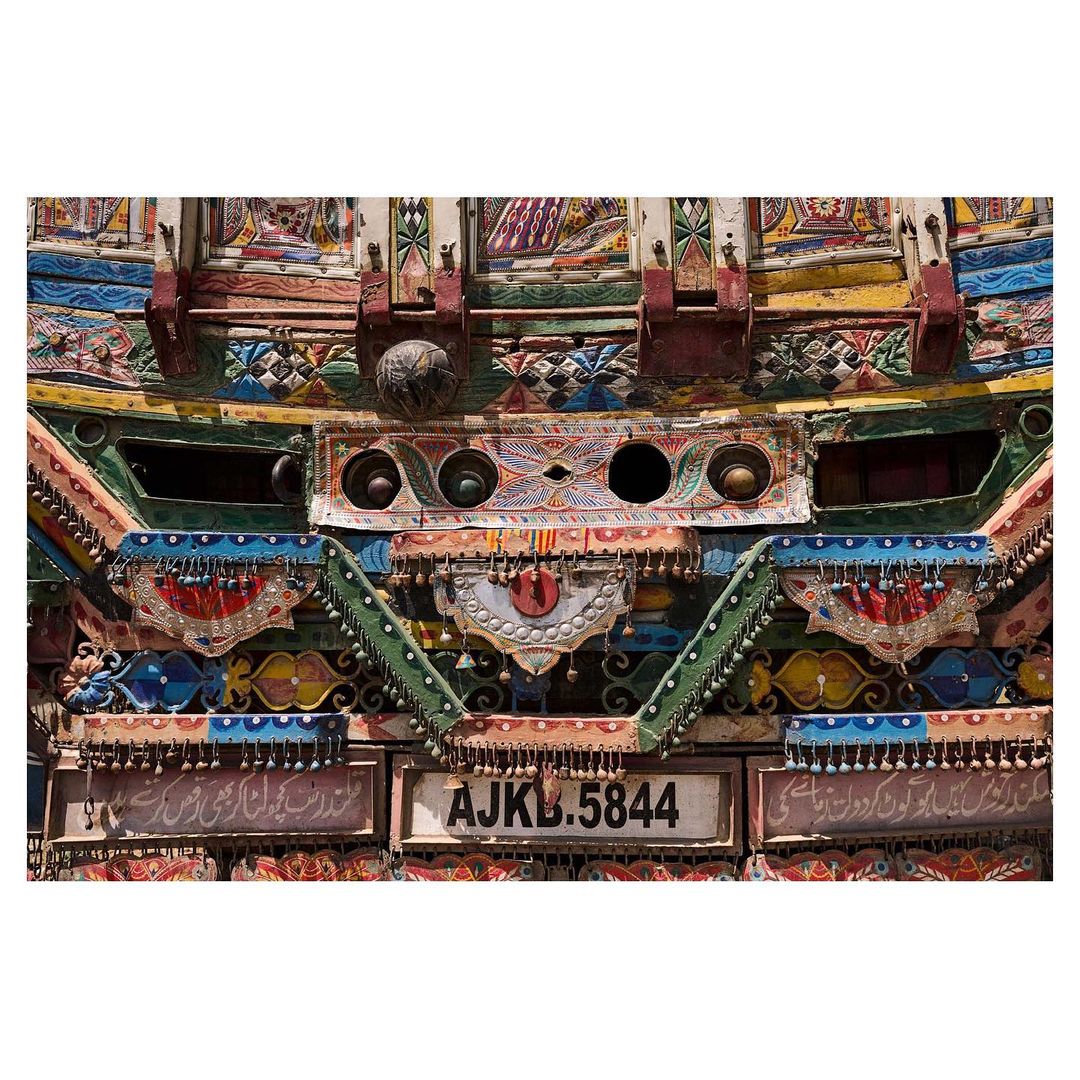 Elaborately decorated truck art featuring colorful embellishments, intricate designs, and artistic details in a close-up view.
