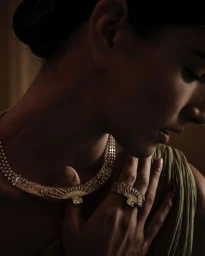 Close-up portrait of a woman wearing an ornate diamond necklace and matching ring, photographed by Alistair Taylor-Young.