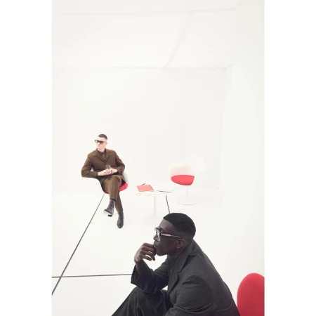 Two men seated in a minimalist white studio space, photographed by Alistair Taylor-Young.
