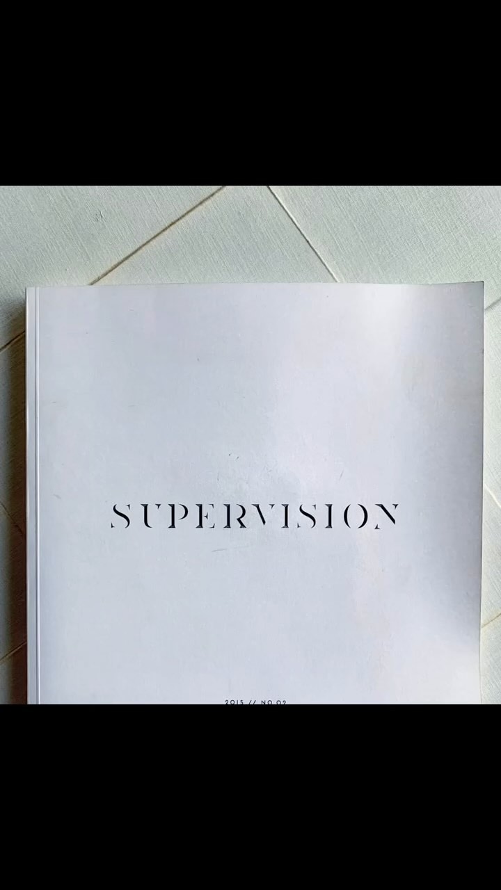 A white softcover book titled 'Supervision' lies on a white surface, shot in soft, natural lighting.