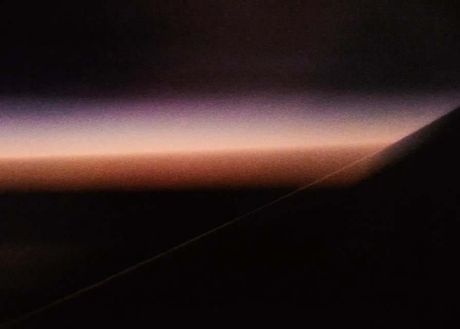 Abstract horizon featuring a gradient of purple, orange, and black hues, creating a sense of depth and mystery in a minimalist composition.