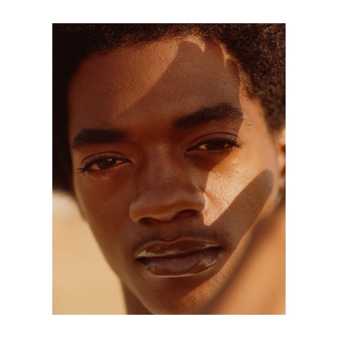 Close-up portrait of a Black man with warm lighting and distinct shadows cast across his face by photographer Anthony Blasko