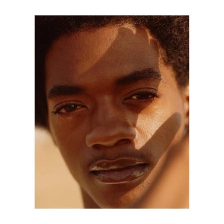 Close-up portrait of a Black man with warm lighting and distinct shadows cast across his face by photographer Anthony Blasko