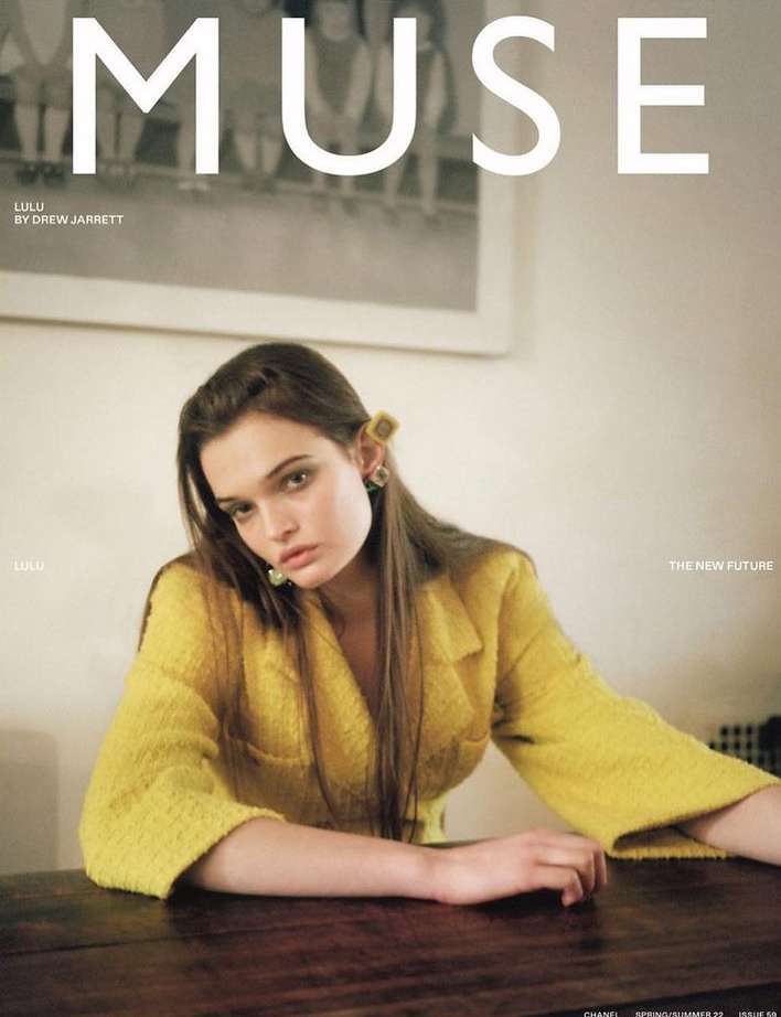 Magazine cover featuring a woman in a yellow blazer sitting at a dark wooden table, with the word 'MUSE' in large white letters.