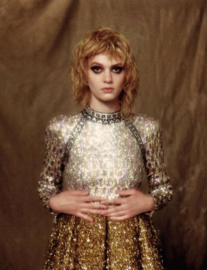 Portrait of a blonde woman wearing a sequined dress with a textured neutral backdrop by photographer Drew Jarrett.