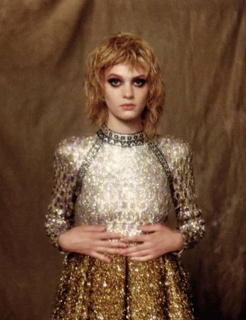 Portrait of a blonde woman wearing a sequined dress with a textured neutral backdrop by photographer Drew Jarrett.
