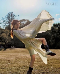 Woman in polka dot dress with flowing fabric outdoors wearing dark boots by Drew Jarrett