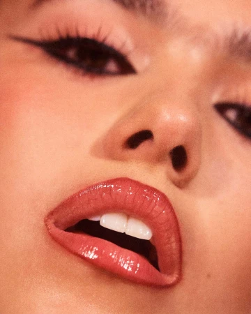 Extreme close-up macro portrait of a model featuring winged eyeliner and glossy red lips, captured by Rory Payne.
