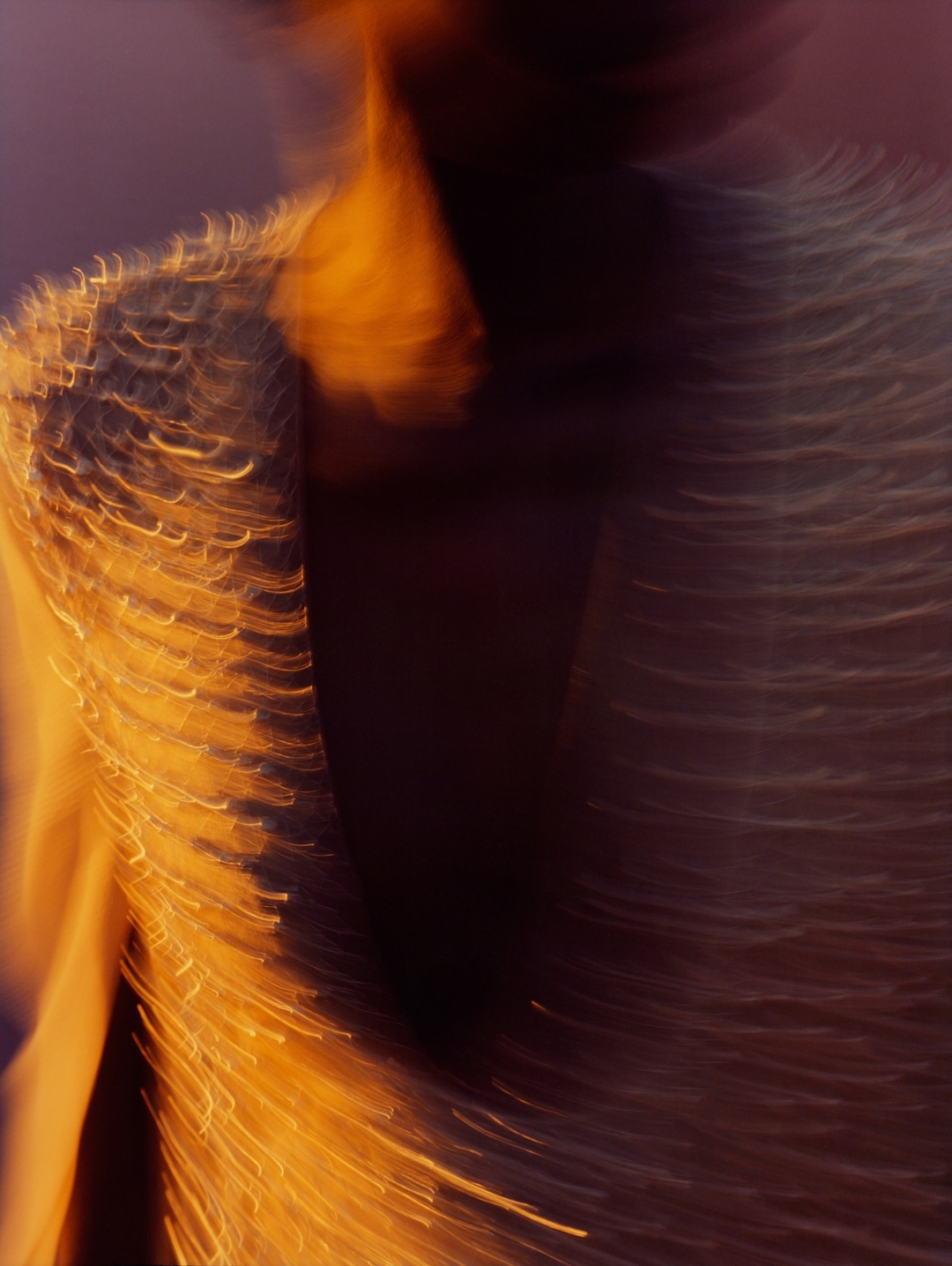 Close-up motion-blurred portrait of a person wearing a textured fringe garment by photographer Rory Payne