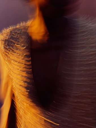 Close-up motion-blurred portrait of a person wearing a textured fringe garment by photographer Rory Payne