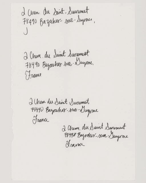 Close-up on a white sheet of paper displaying four handwritten addresses in black ink, showcasing cursive handwriting and document texture.